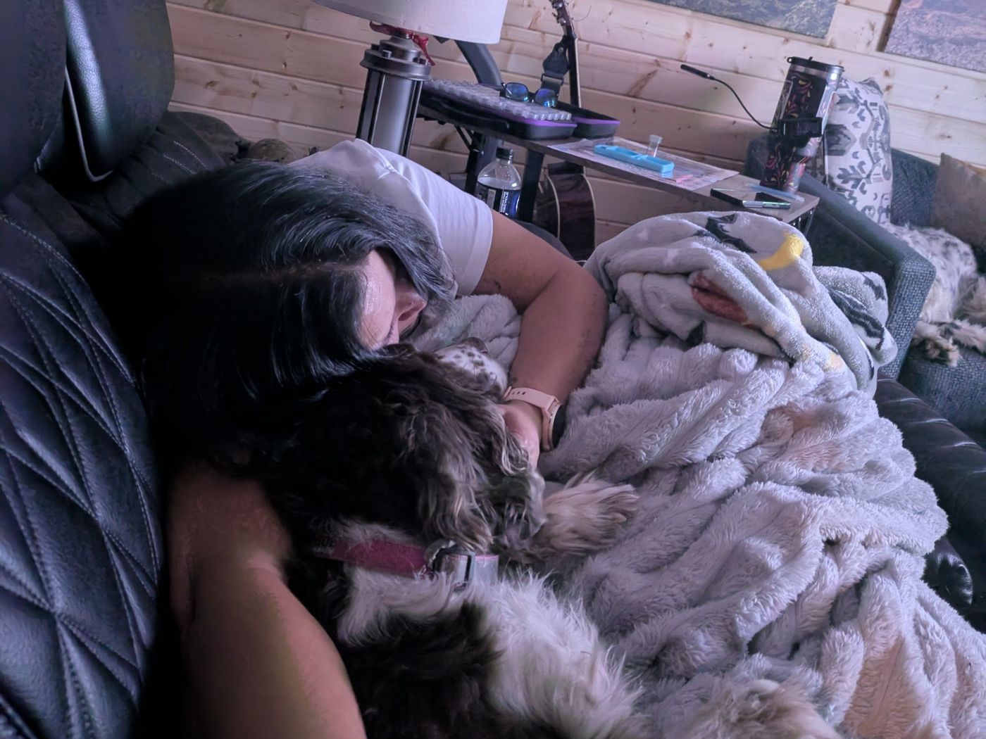Drea and Maggie curled up together under a blanket on the couch.